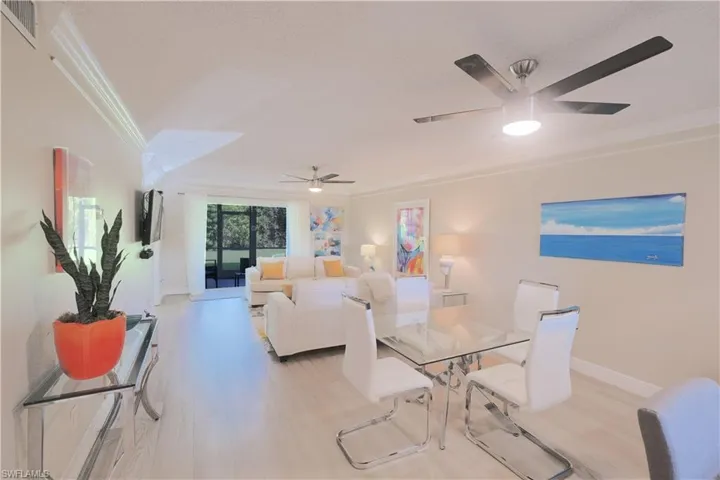 Dining area with ceiling fan, light hardwood / wood-style flooring, and crown molding