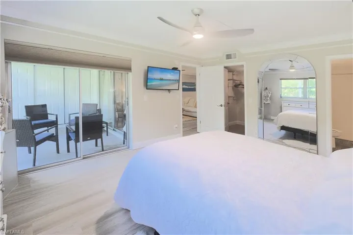 Bedroom with light hardwood / wood-style flooring, access to exterior, a spacious closet, a closet, and ceiling fan