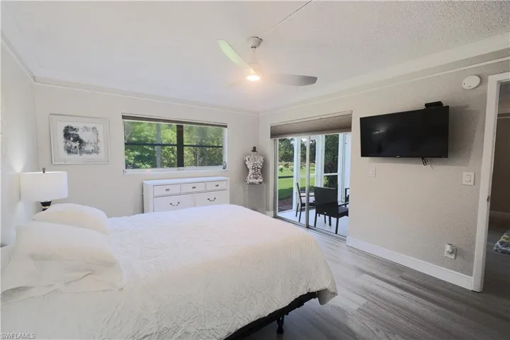 Bedroom with access to outside, hardwood / wood-style flooring, ornamental molding, and ceiling fan