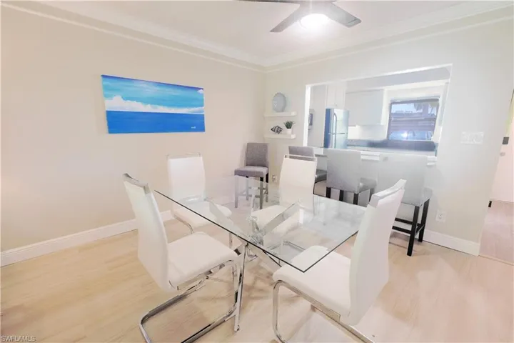 Dining area with glass table, ceiling fan, and light hardwood / wood-style flooring