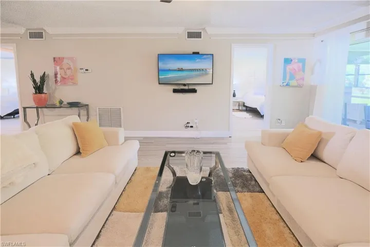 Living room with hardwood / wood-style flooring and crown molding