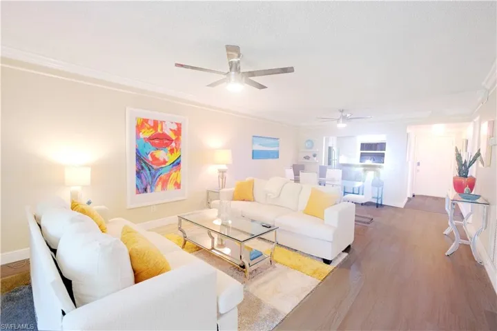 Living room featuring crown molding, ceiling fan, a textured ceiling, and hardwood / wood-style floors