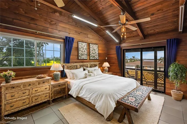 DIGITAL STAGING: Bedroom featuring wooden ceiling, lofted ceiling with beams, wooden walls, ceiling fan, and light tile patterned floors