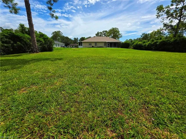 View of green lawn with a sunroom