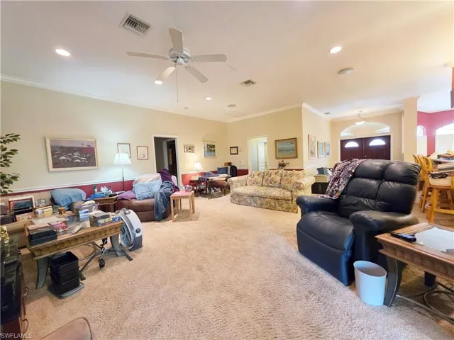 Living area with crown molding, carpet floors, recessed lighting, and a ceiling fan