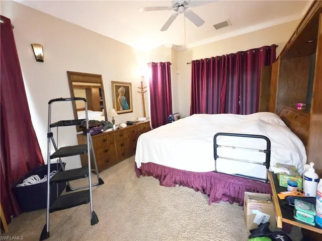 Carpeted bedroom featuring a ceiling fan and ornamental molding