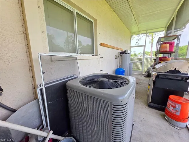 Exterior view of stucco siding, a water softener, and a water pressure tank