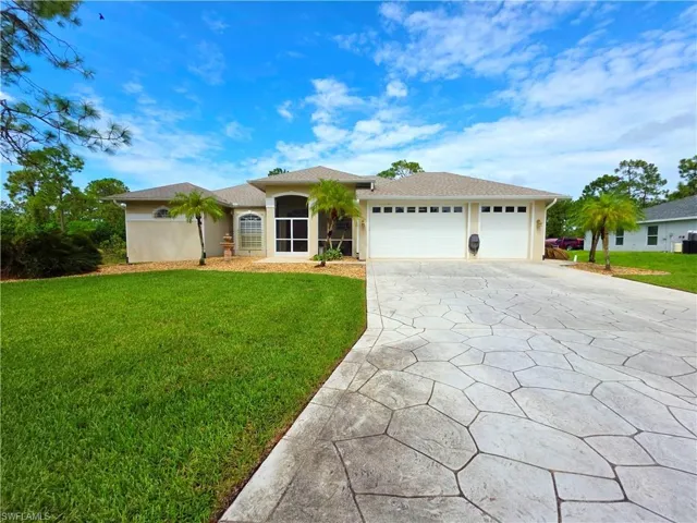 Single story home with driveway, a front lawn, a garage, roof with shingles, and stucco siding