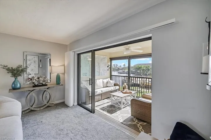 Carpeted living area featuring baseboards