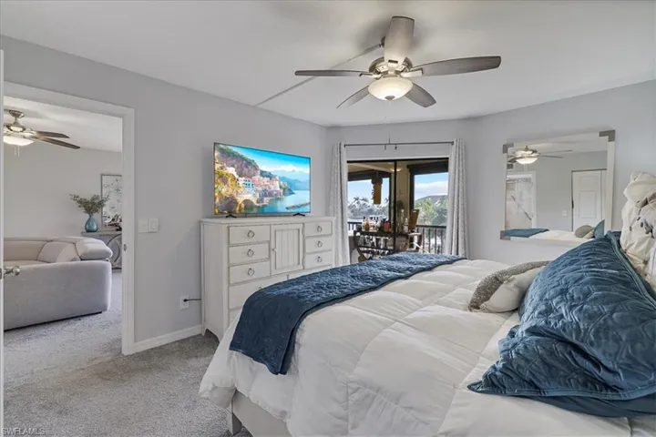 Carpeted bedroom featuring access to outside and a ceiling fan
