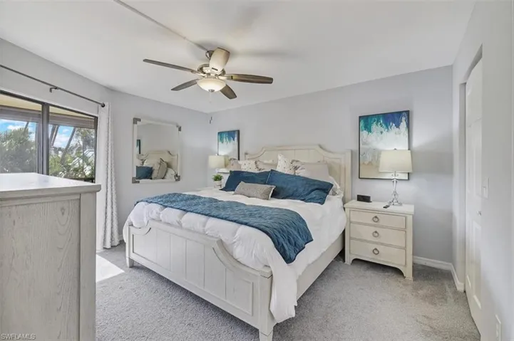 Bedroom featuring light carpet, ceiling fan, and a closet