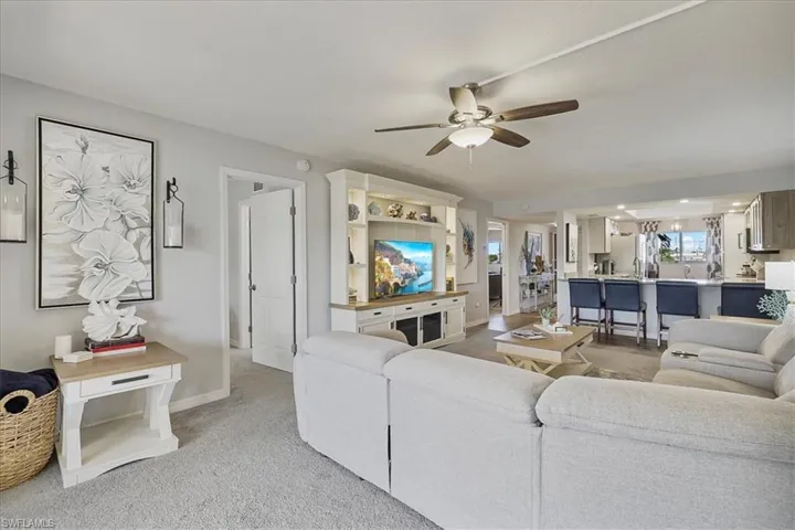 Living area featuring light carpet and a ceiling fan