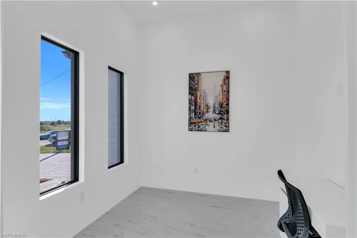 Unfurnished office with baseboards and marble look tile flooring