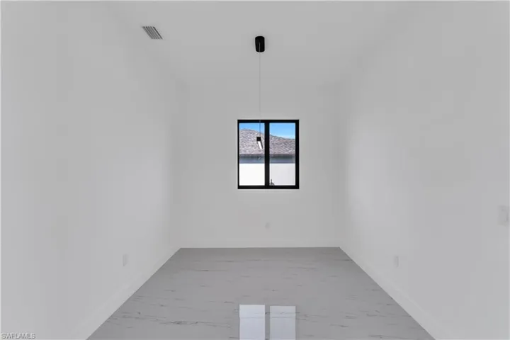 Unfurnished room featuring baseboards and light marble finish flooring
