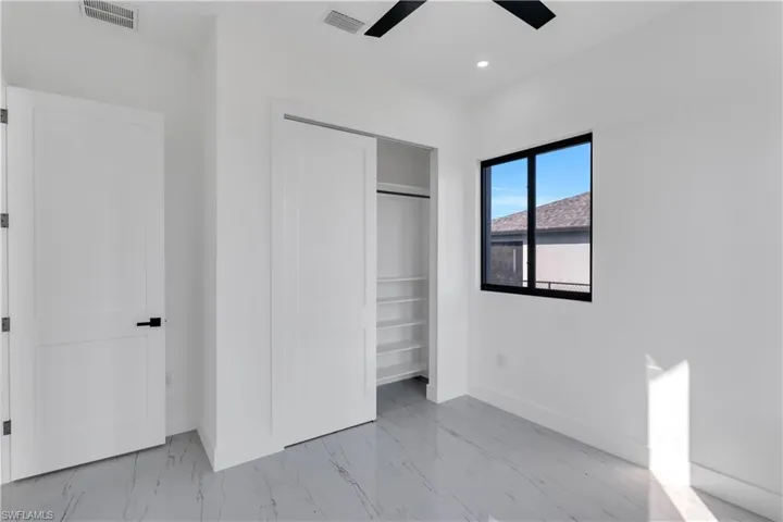 Unfurnished bedroom with a closet, recessed lighting, ceiling fan, and light marble finish flooring