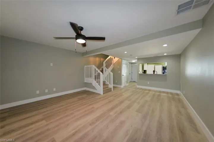 Unfurnished living room with ceiling fan and light laminate flooring