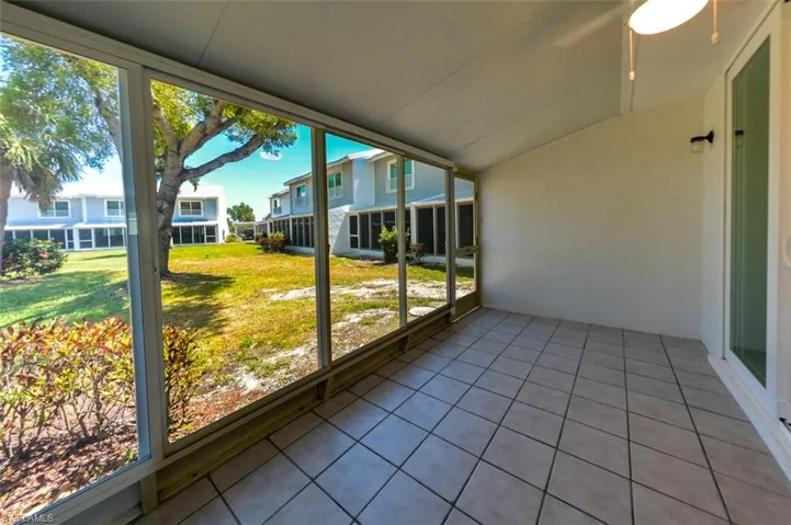 Unfurnished sunroom featuring a wealth of natural light, ceiling fan, and lofted ceiling