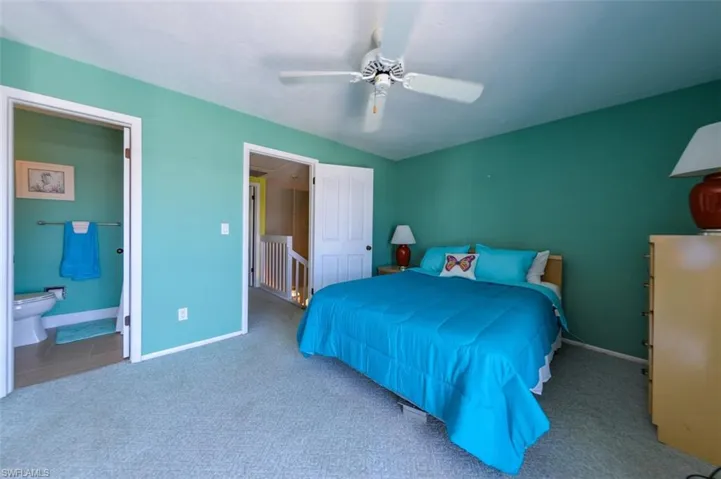 Bedroom featuring carpet, ceiling fan, and ensuite bathroom