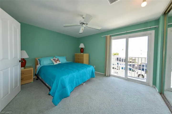 Carpeted bedroom featuring ceiling fan and access to exterior