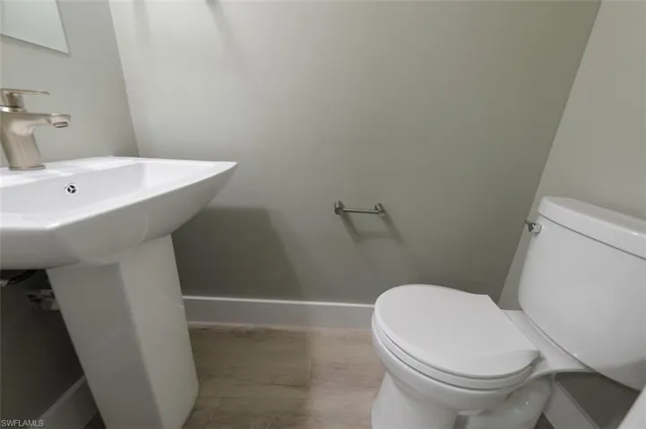 Bathroom with laminate flooring, sink, and toilet