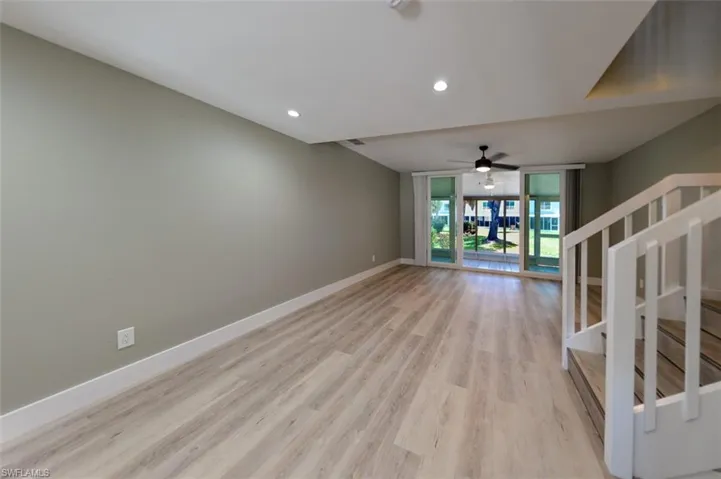 Unfurnished living room with floor to ceiling windows, ceiling fan, and light hardwood / wood-style flooring
