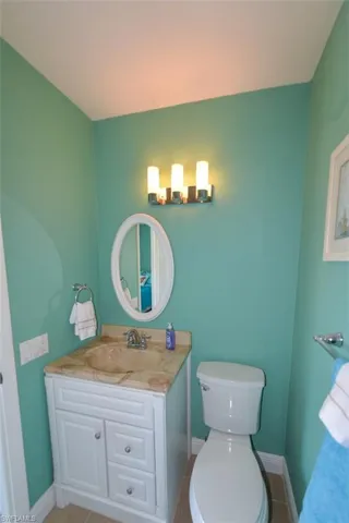 Bathroom featuring tile flooring, toilet, and large vanity