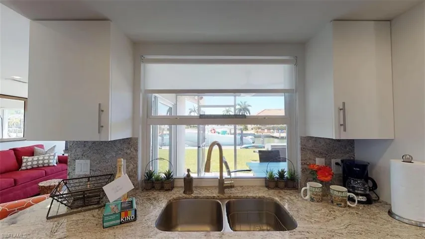 Kitchen with a wealth of natural light, sink, and white cabinets!