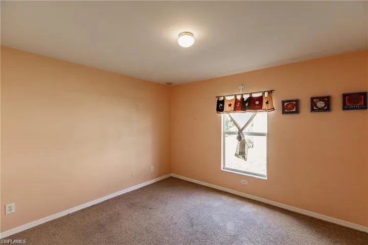 Unfurnished room featuring carpet floors and baseboards