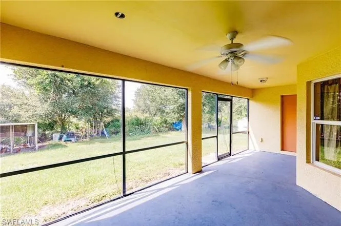 Unfurnished sunroom featuring ceiling fan