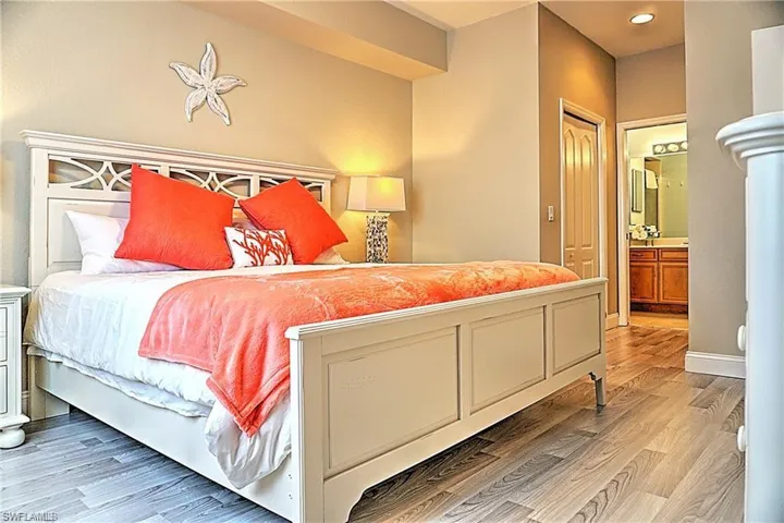 Bedroom with light wood-style floors and ensuite bath