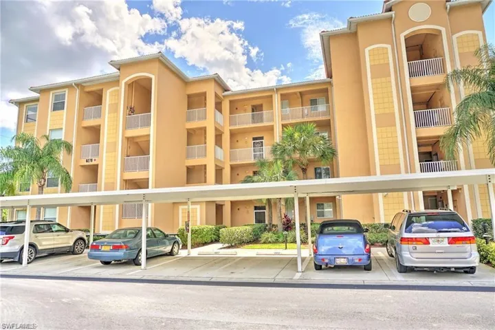 View of apartment building / complex with covered parking