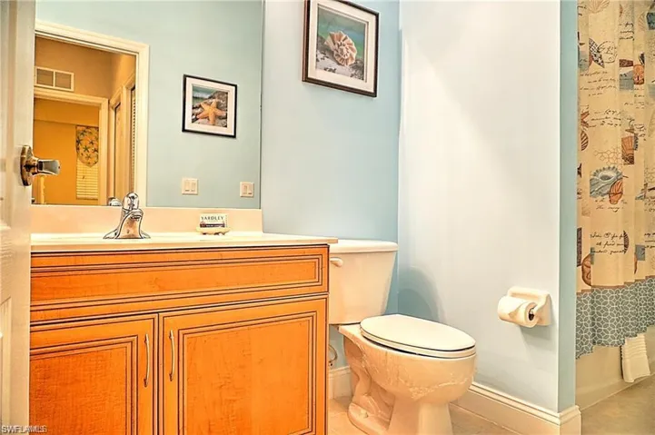 Bathroom featuring vanity, light tile patterned floors, and a shower with shower curtain