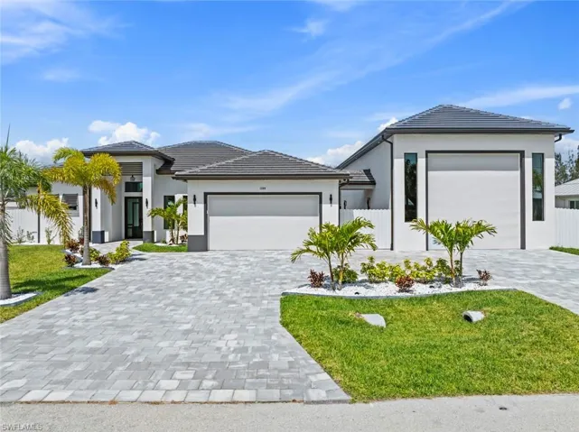 Prairie-style home with a garage, decorative driveway, stucco siding, and a tiled roof