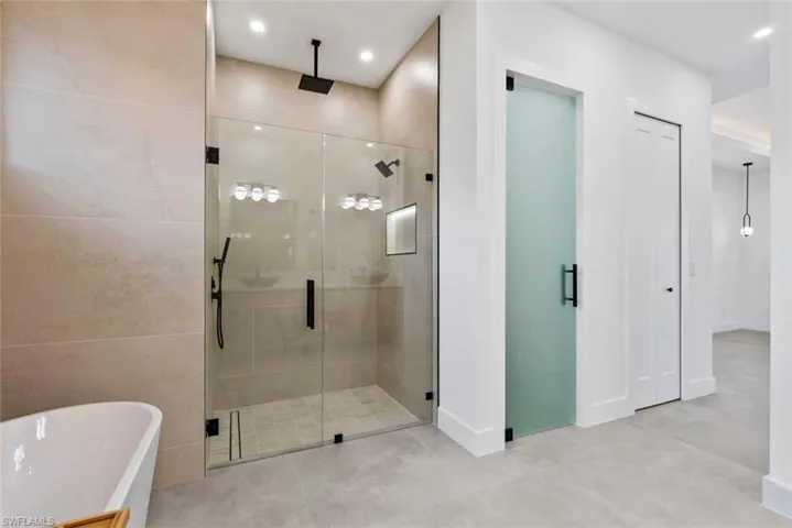 Full bathroom featuring a stall shower, a freestanding tub, and recessed lighting