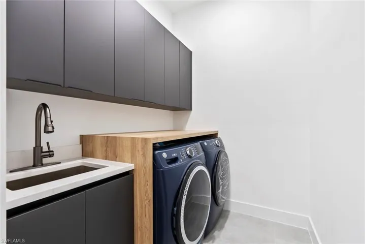 Laundry area with cabinet space, washing machine and clothes dryer, and baseboards