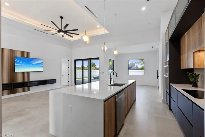 Kitchen with modern cabinets, a sink, dishwasher, a ceiling fan, and healthy amount of natural light