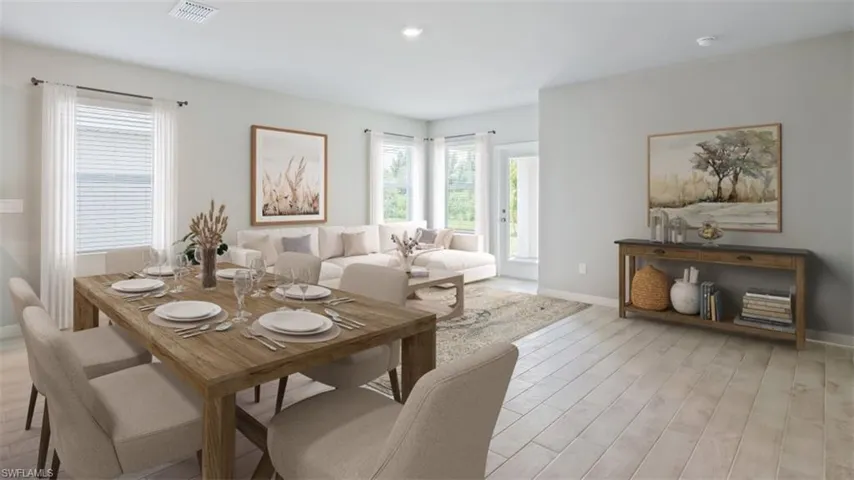 This image is virtually staged. Dining room with light wood-type flooring and baseboards