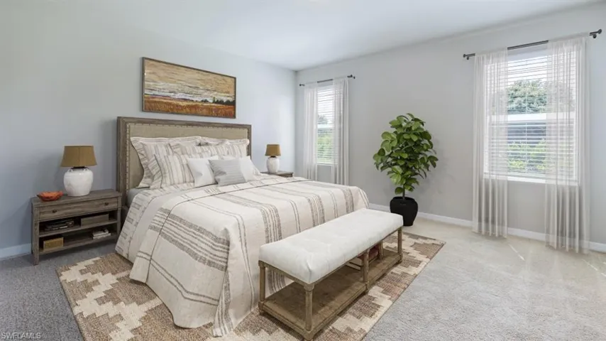 This image is virtually staged. Bedroom with light colored carpet