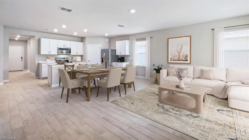 This image is virtually staged. Dining area with light wood finished floors and recessed lighting