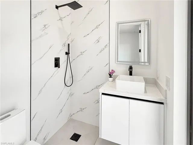 Modern bathroom featuring a rectangular vessel sink on a white floating vanity with a quartz countertop