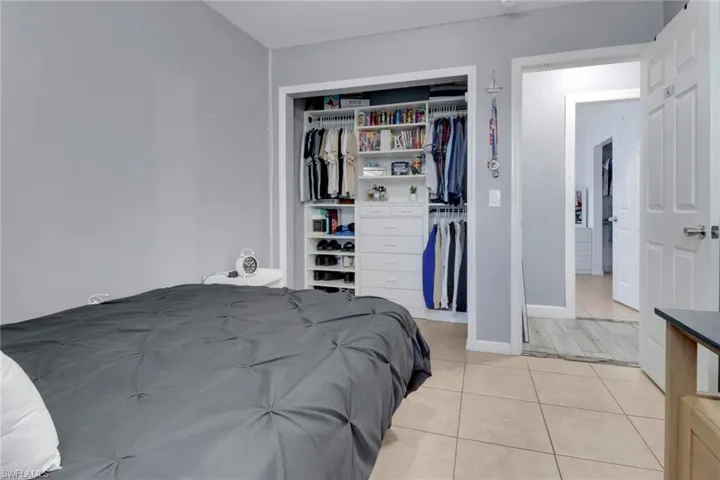 Bedroom with light tile patterned floors, a closet, and baseboards