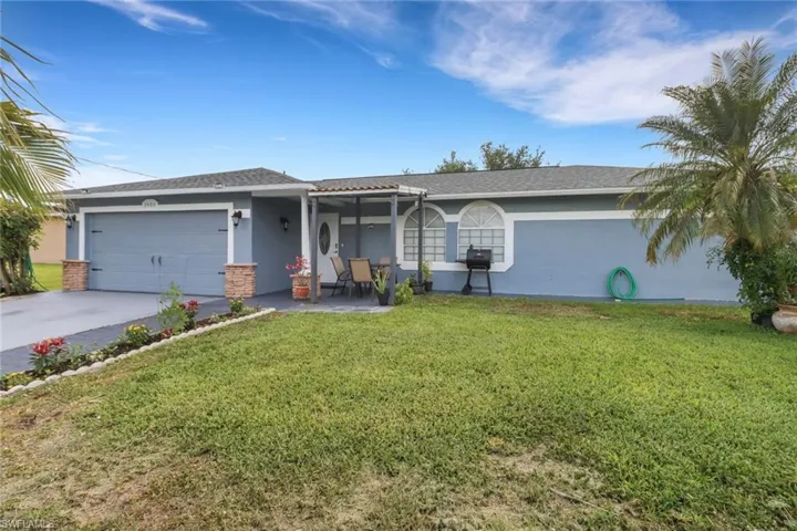 Single story home featuring concrete driveway, a front yard, stucco siding, and an attached garage