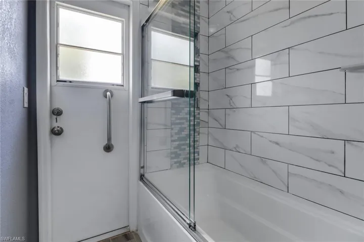 Bathroom with shower / bath combination with glass door