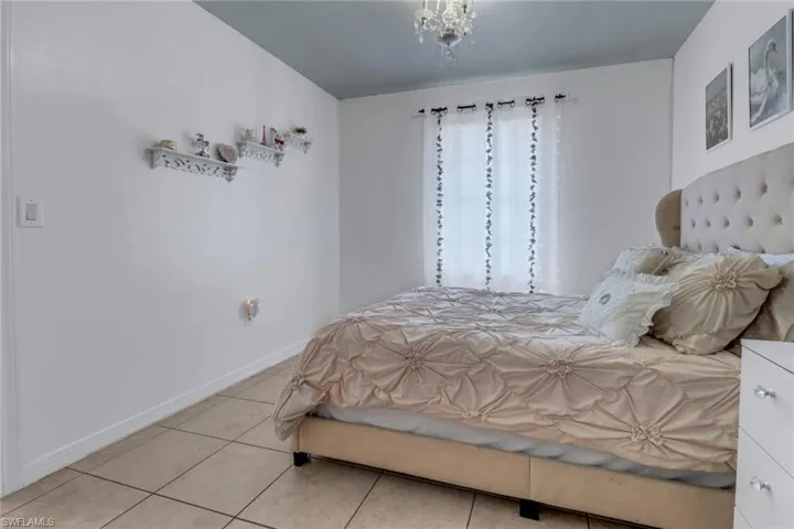 Bedroom featuring baseboards and light tile patterned flooring