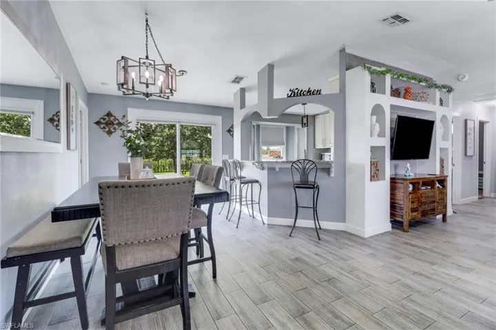 Dining area featuring visible vents, baseboards, and a notable chandelier