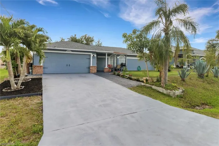 Single story home featuring a front yard, a garage, and concrete driveway