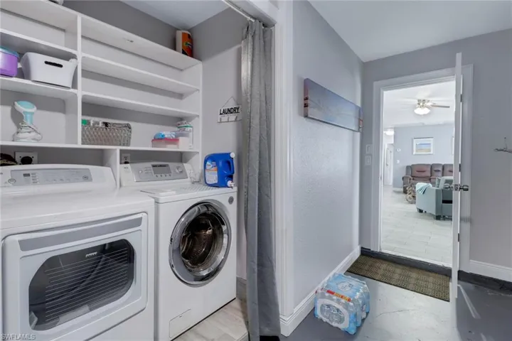 Laundry area featuring washer and clothes dryer, ceiling fan, laundry area, and baseboards