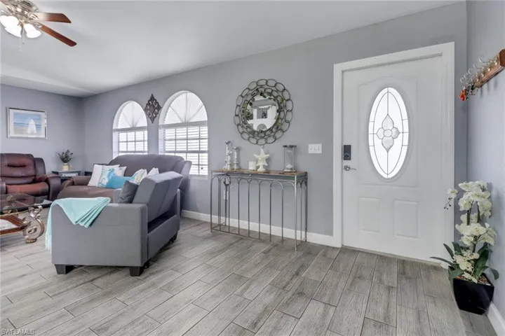 Foyer featuring ceiling fan, light wood-style floors, and baseboards