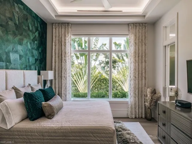 Second Primary Bedroom with an accent wallpapered wall, wood finished floors, and a tray ceiling