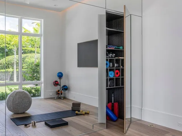Exercise room featuring floor to ceiling mirrored wall